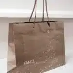 クリスマスを思わせるシアーなゴールド紙袋を読む