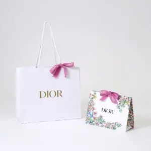 有名コスメブランドの純白ボディに映えるピンクリボンが可愛いオリジナル紙袋と、無数の花々をフルカラー印刷で表現した美しいオリジナルプレゼントバッグ