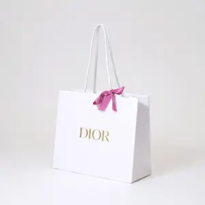 有名コスメブランドの純白ボディに映える、高級感のある箔押しロゴとピンクリボンが可愛いオリジナル紙袋
