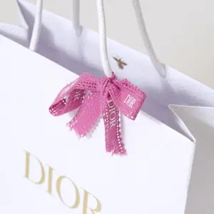 有名コスメブランドの純白ボディに映える、高級感のある箔押しロゴとピンクリボンが可愛いオリジナル紙袋