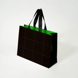 ロゴを正面ではなくマチに配した、ブラックとグリーンの対比がハイセンスな紙袋