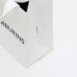 韓国コスメブランドが手がける、側面にブランド情報がプリントされた、ホワイトベースのシンプルなオリジナル紙袋