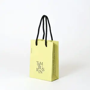 韓国コスメブランドが手がける、遊び心のあるロゴが印字された、トレンド感溢れるイエローベースのオリジナル紙袋