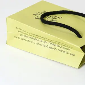 韓国コスメブランドが手がける、側面にブランドコンセプトがプリントされた、トレンド感溢れるイエローベースのオリジナル紙袋