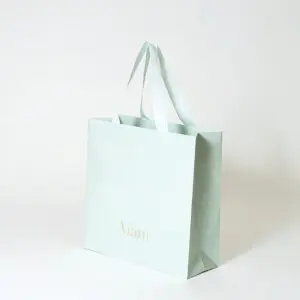 V字折り底とゴールドの箔押し加工を施した、鮮やかなミントグリーン色のフレグランスブランドのオリジナル紙袋