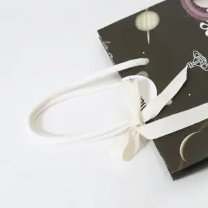 ハンドルにホワイトのアクリルスピンドルを使用した、イギリス発アパレルブランドの神秘的でロックなオリジナル紙袋