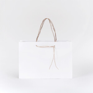 清潔感のあるホワイトと、すっと垂れるハンドルが上品な印象を与える、和洋菓子専門店のオリジナル紙袋