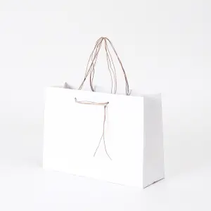 清潔感のあるホワイトと、すっと垂れるハンドルが上品な印象を与える、和洋菓子専門店のオリジナル紙袋