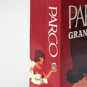 主人公の女性がPARCOの建物を手に持つイラストが描かれた、「パプリカ」20周年コラボオリジナル紙袋の側面デザイン